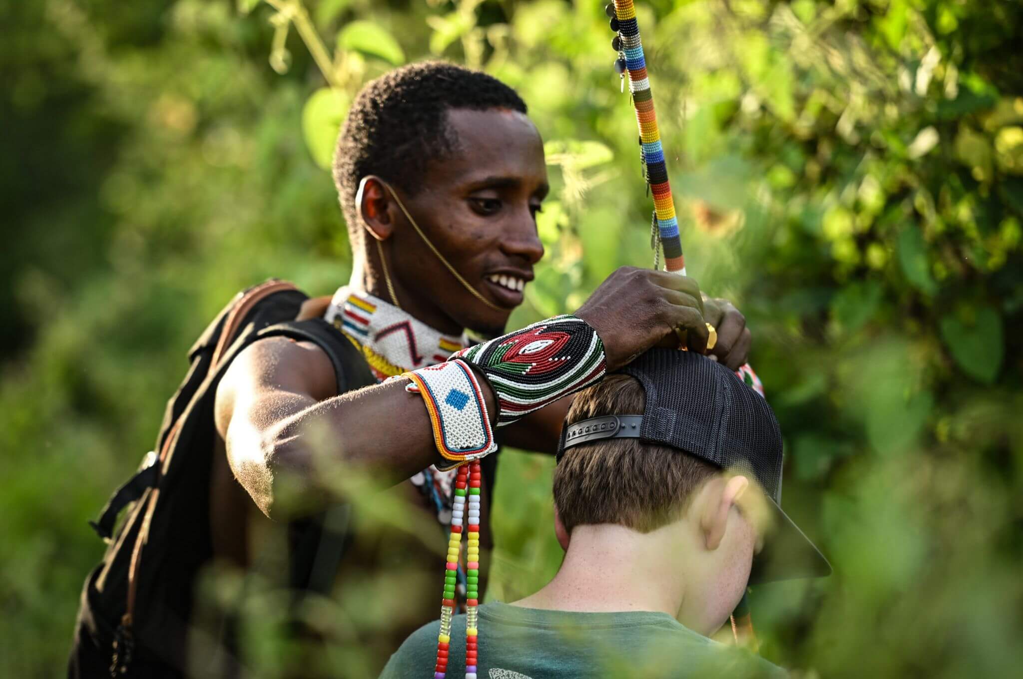 A Samburu warrior adorns a curious young guest with his traditional headdress. © Rodger Bowren